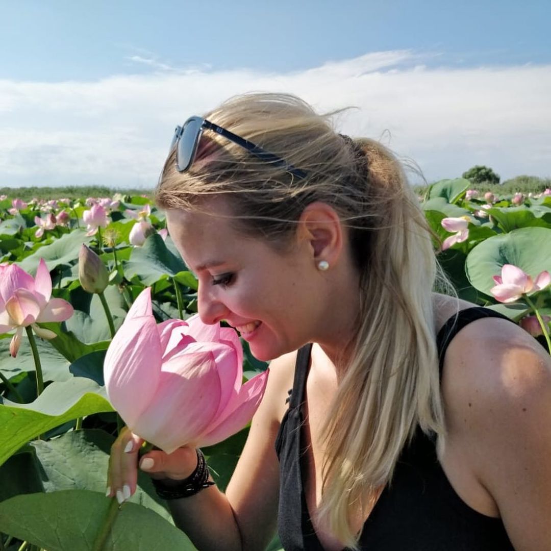 tourist smelling the waterlilies in the danube delta boat oturs with nearchus Nautictour Mahmudia