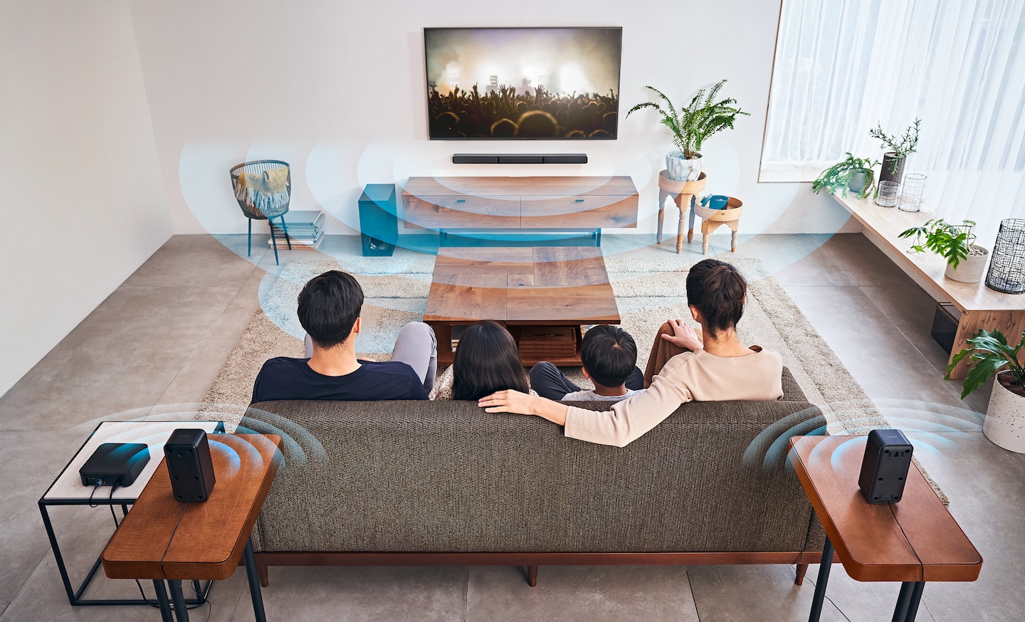 A family gathered around the HT-S40R soundbar, captivated by a thrilling movie scene on their TV.